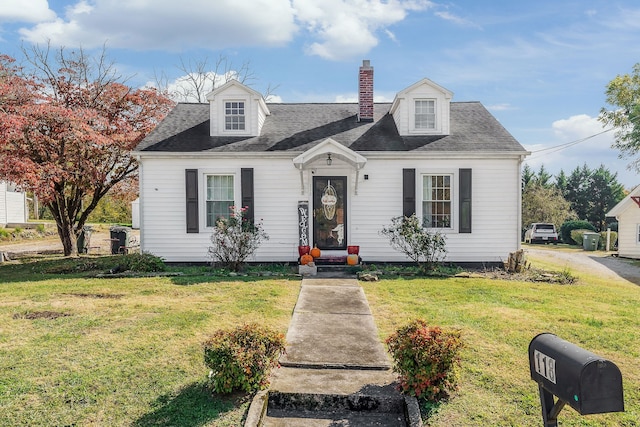 cape cod house featuring a front yard