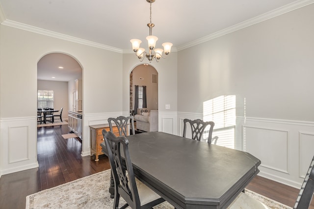 dining area featuring dark hardwood / wood-style floors, ornamental molding, and a chandelier