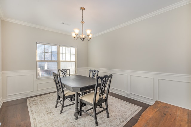 dining room featuring a chandelier, crown molding, and dark wood-type flooring