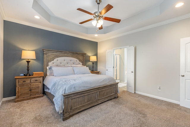 carpeted bedroom featuring a raised ceiling, ceiling fan, and ornamental molding