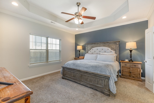 bedroom with ceiling fan, crown molding, light carpet, and a tray ceiling