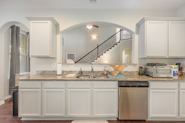 kitchen with dark hardwood / wood-style flooring, light stone counters, stainless steel dishwasher, sink, and white cabinets