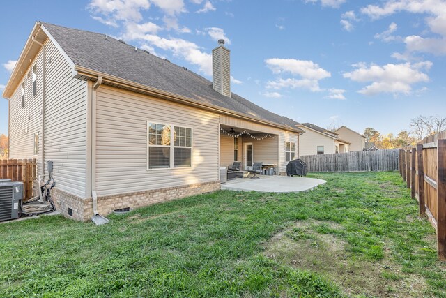 rear view of property featuring a yard, central AC, and a patio area