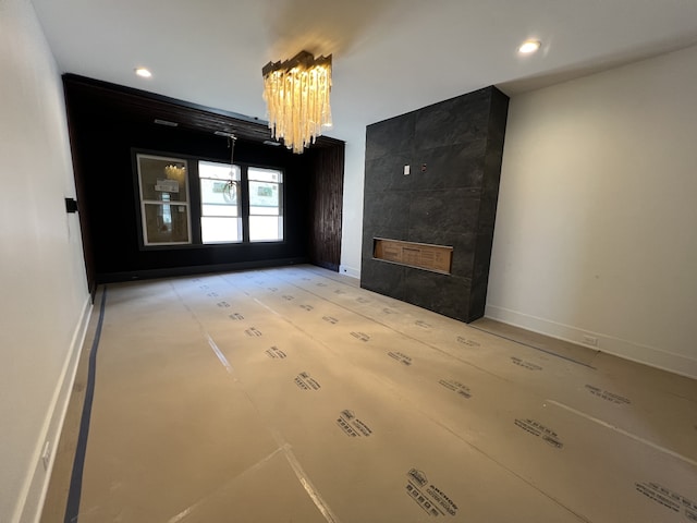 unfurnished living room with a tile fireplace and a notable chandelier