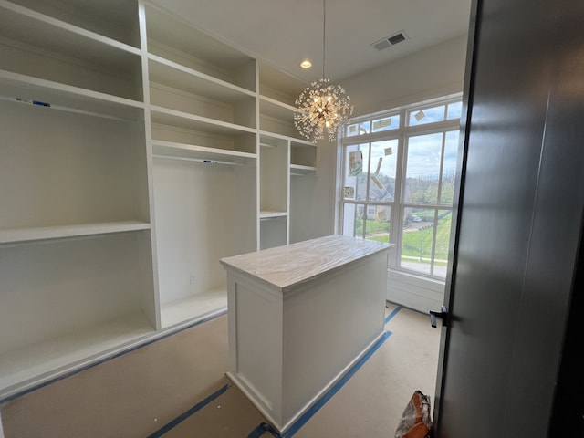 walk in closet with an inviting chandelier