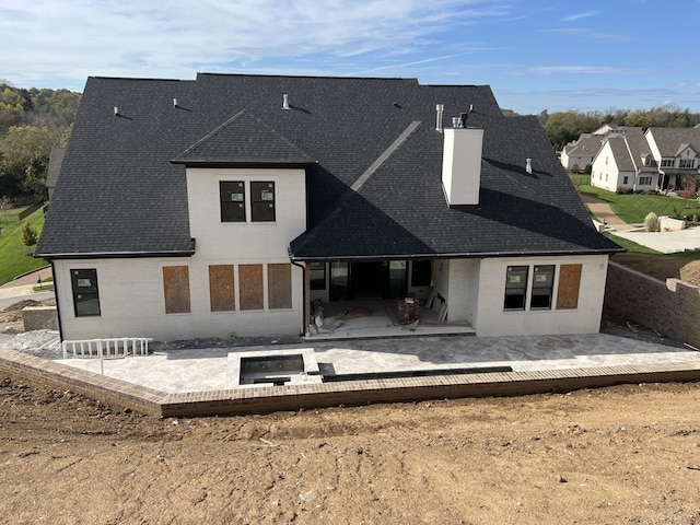 rear view of property with a jacuzzi and a patio area