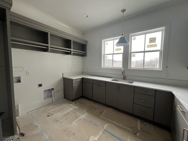 kitchen with sink, decorative light fixtures, and ornamental molding