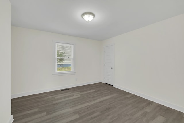 spare room featuring dark wood-type flooring