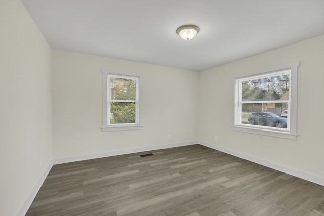 unfurnished room featuring a wealth of natural light and hardwood / wood-style floors