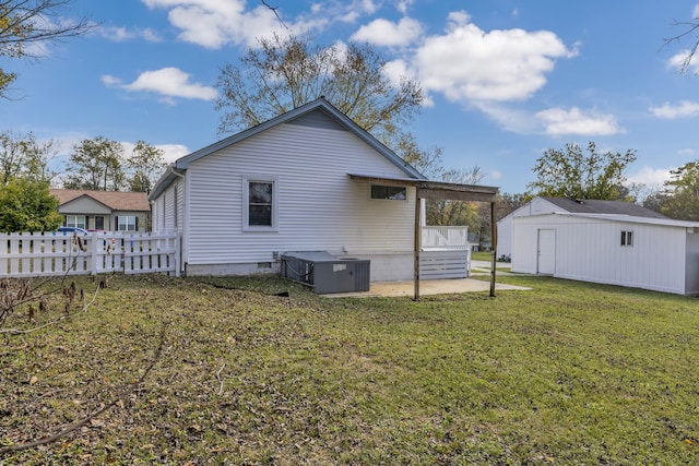 rear view of house featuring cooling unit, a patio, and a yard