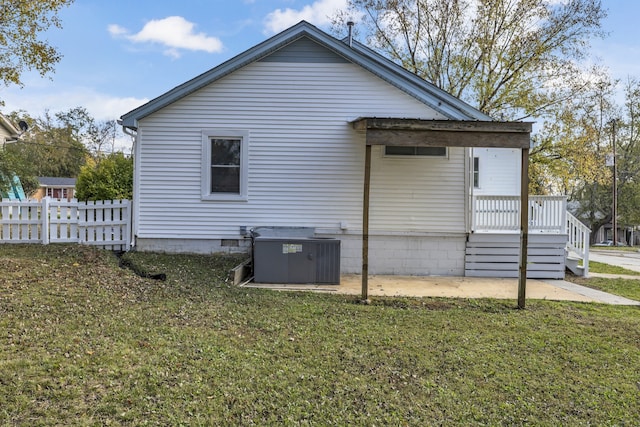 view of side of property with a yard and cooling unit