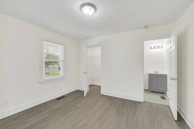 unfurnished bedroom with light wood-type flooring and a closet