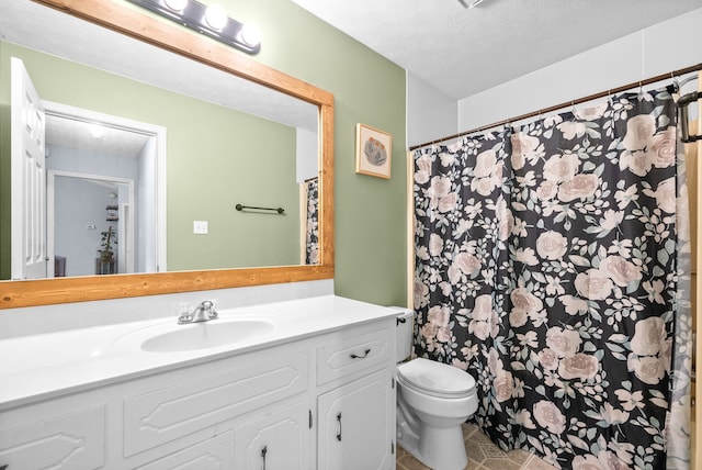 bathroom with tile patterned flooring, vanity, a textured ceiling, and toilet