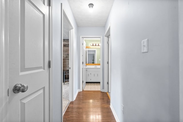 hall featuring hardwood / wood-style floors and a textured ceiling