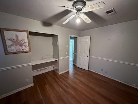 unfurnished bedroom with dark wood-type flooring and ceiling fan