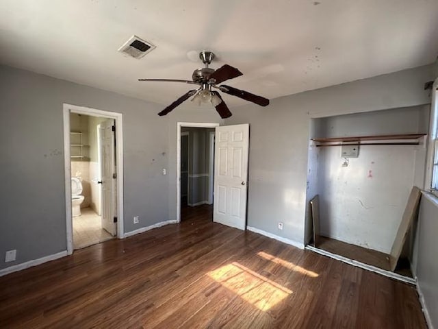 unfurnished bedroom with dark hardwood / wood-style floors, connected bathroom, and ceiling fan