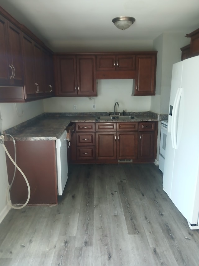 kitchen featuring white appliances, sink, and light wood-type flooring