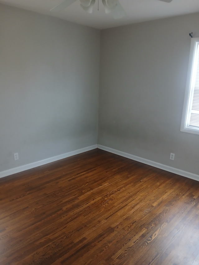 spare room with dark wood-type flooring and ceiling fan