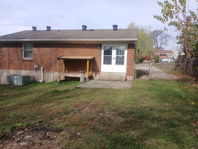 rear view of house featuring central AC unit, a patio area, a yard, and french doors