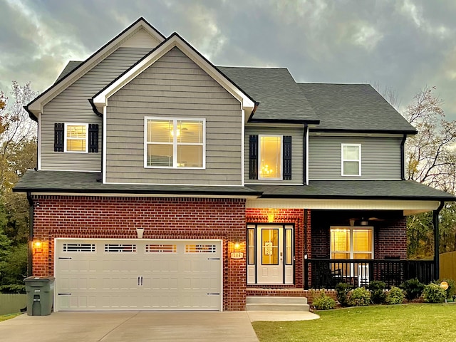 view of front facade featuring a garage, a front yard, and a porch