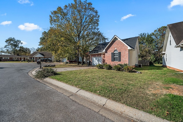 view of front of home featuring a garage, central AC unit, and a front yard