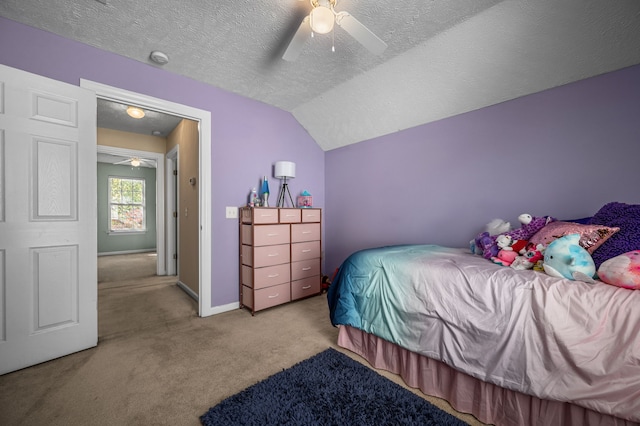 carpeted bedroom with lofted ceiling, a textured ceiling, and ceiling fan