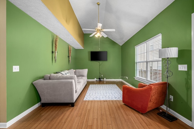 living room featuring ceiling fan, vaulted ceiling, and light hardwood / wood-style floors