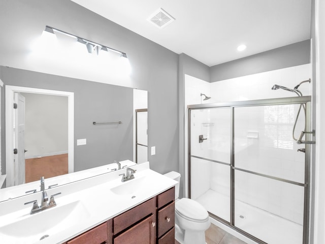 bathroom featuring tile patterned flooring, an enclosed shower, vanity, and toilet