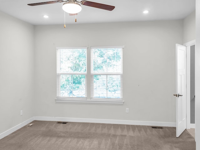 empty room featuring ceiling fan and light colored carpet