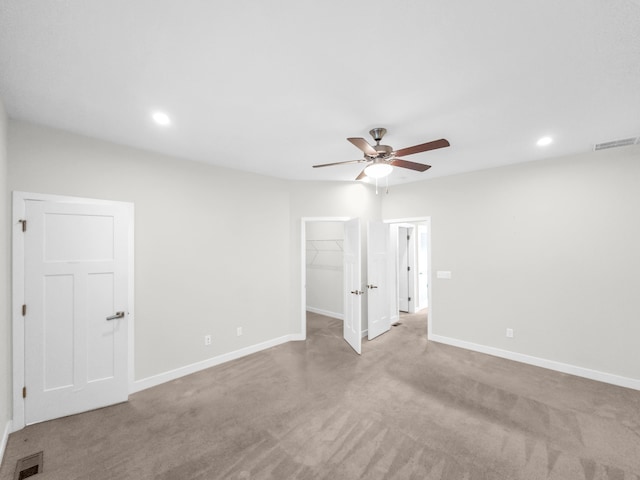 spare room featuring light carpet and ceiling fan