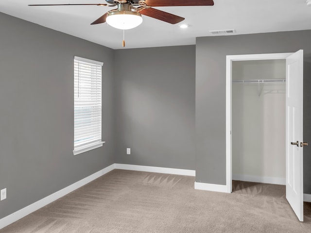 unfurnished bedroom with ceiling fan, a closet, and light colored carpet