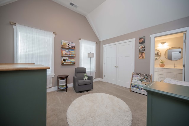 sitting room with light colored carpet, sink, and vaulted ceiling