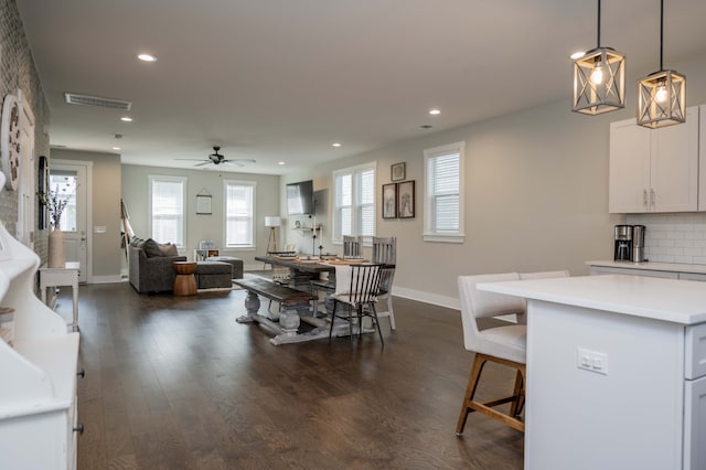 dining space with dark wood-type flooring and ceiling fan