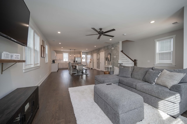 living room with dark hardwood / wood-style flooring and ceiling fan