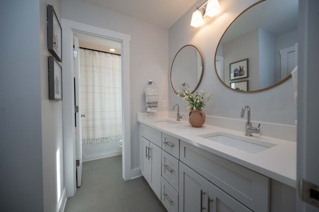 bathroom with toilet, vanity, and tile patterned flooring