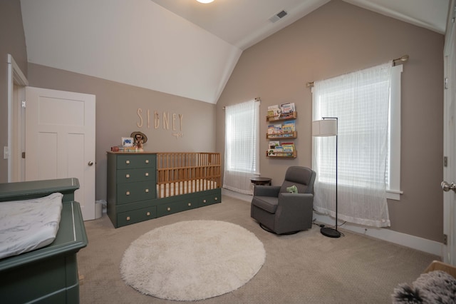 bedroom with lofted ceiling, multiple windows, a nursery area, and carpet floors