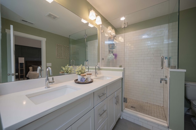 bathroom featuring toilet, vanity, an enclosed shower, and tile patterned flooring