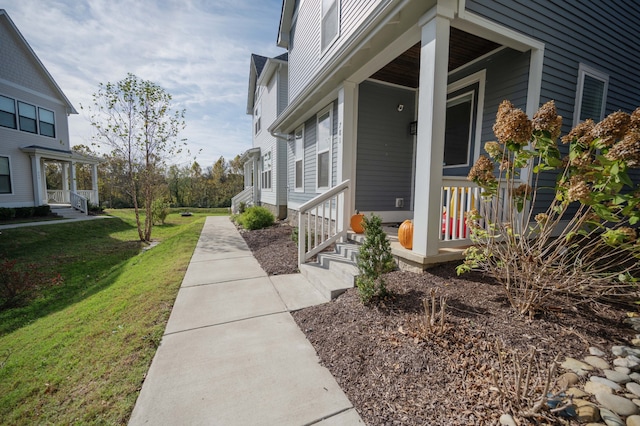 view of side of property featuring a porch and a lawn