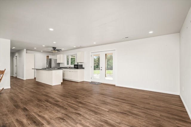 unfurnished living room featuring french doors, ceiling fan, and dark hardwood / wood-style flooring