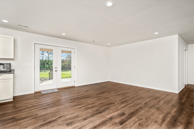 unfurnished living room with dark hardwood / wood-style floors and french doors