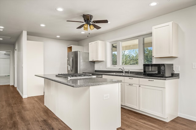 kitchen with a kitchen island, white cabinetry, dark hardwood / wood-style flooring, stainless steel refrigerator with ice dispenser, and sink