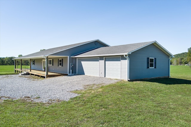 ranch-style house featuring a garage, a front yard, and covered porch