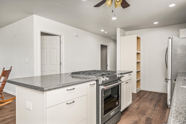 kitchen featuring white cabinetry, appliances with stainless steel finishes, dark hardwood / wood-style flooring, dark stone countertops, and ceiling fan