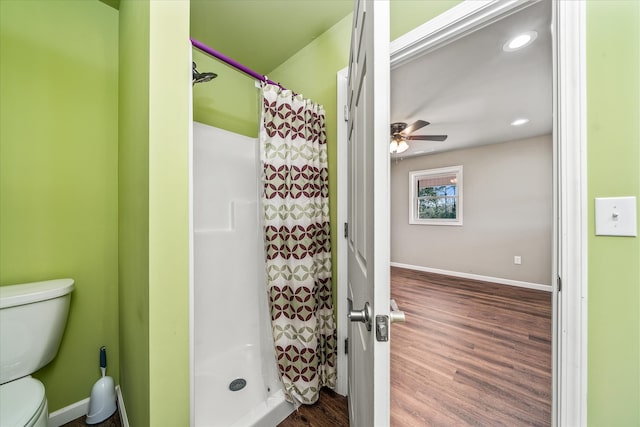 bathroom with toilet, ceiling fan, wood-type flooring, and curtained shower