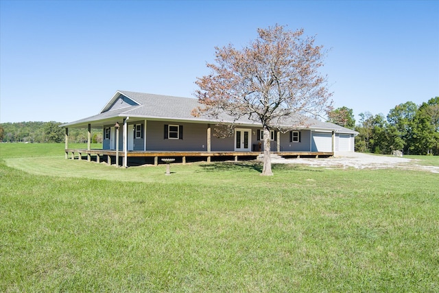 view of front of property featuring a garage, a front lawn, and a porch