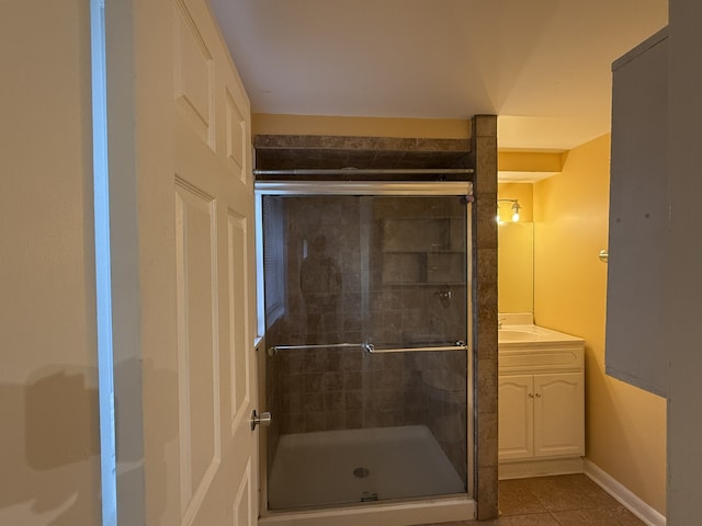 bathroom with walk in shower, vanity, and tile patterned floors