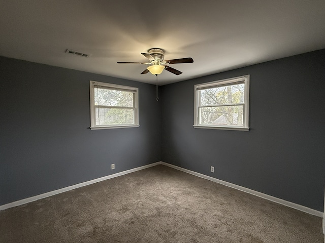 carpeted spare room with ceiling fan and plenty of natural light