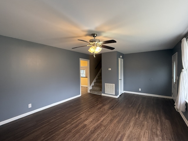 empty room featuring dark wood-type flooring and ceiling fan