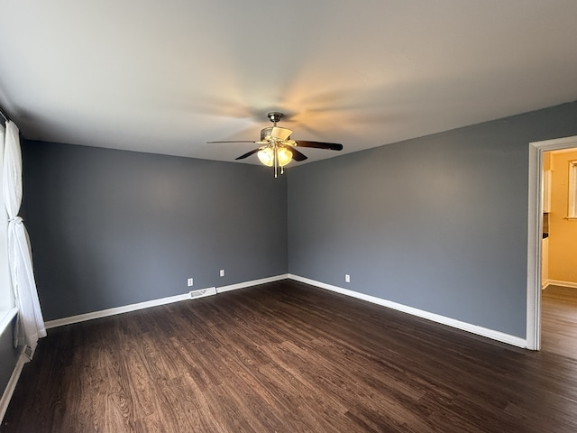 empty room with dark hardwood / wood-style floors and ceiling fan