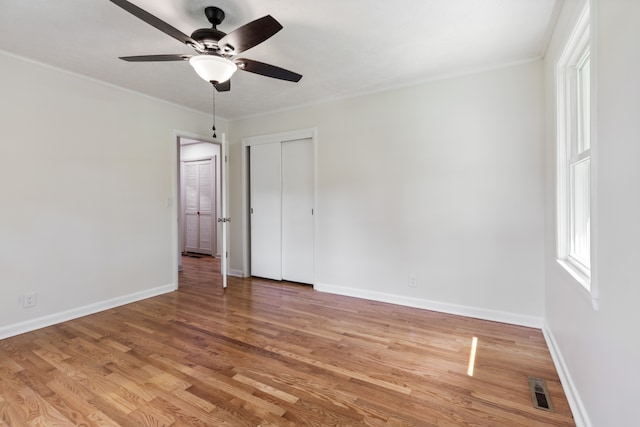 empty room with ornamental molding, hardwood / wood-style floors, and ceiling fan